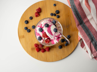 Lody śmietankowo-malinowe z owocami. Maliny i borówki. Widok z góry, jasne tło. © PhotoHunter