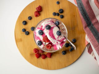 Lody śmietankowo-malinowe z owocami. Maliny i borówki. Widok z góry, jasne tło. © PhotoHunter