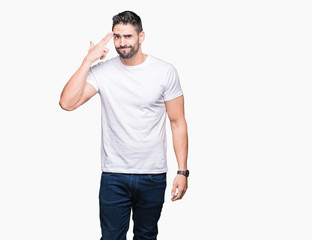 Handsome man wearing white t-shirt over white isolated background Shooting and killing oneself pointing hand and fingers to head, suicide gesture.