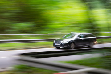 Fototapeta na wymiar Intentional camera movement of a car in the forest