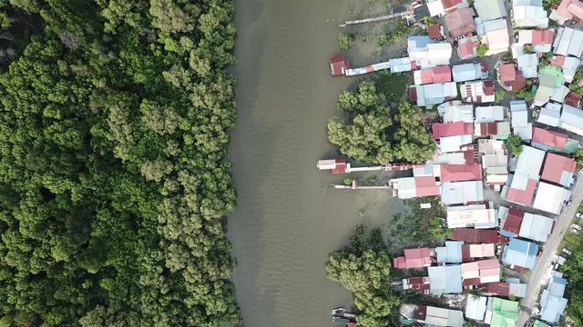 Aerial view river separate the mangrove forest and Malays housing village at Kuala Juru, Penang.