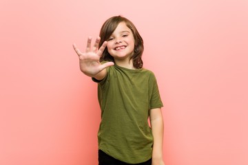 Little boy smiling cheerful showing number five with fingers.