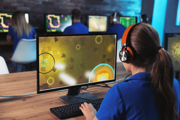 Woman playing video game in internet cafe