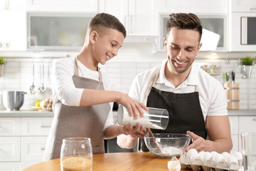 Dad and son cooking together in kitchen