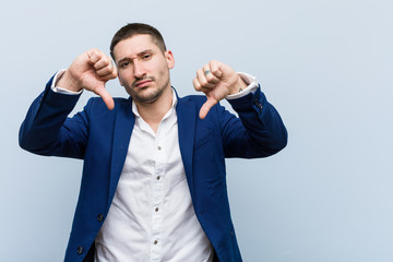 Young business caucasian man showing thumb down and expressing dislike.