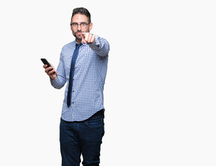 Young business man using smartphone over isolated background pointing with finger to the camera and to you, hand sign, positive and confident gesture from the front