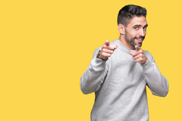Fototapeta premium Young handsome man wearing sweatshirt over isolated background pointing fingers to camera with happy and funny face. Good energy and vibes.
