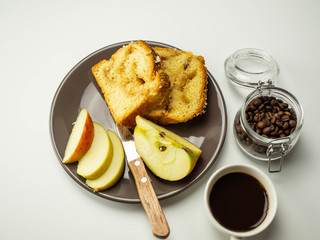 Jabłkowe ciasto pokrojone na talerzu. Plasterki jabłka. Widok z góry, jasne tło.