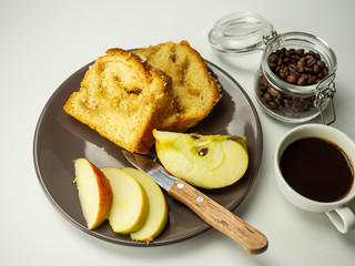 Jabłkowe ciasto pokrojone na talerzu. Plasterki jabłka. Widok z góry, jasne tło.