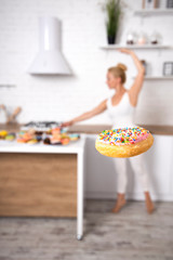 Ballerina and Donuts. Pretty blonde ballerina in tutu skirt reaching for a donut. A lot of Donuts.