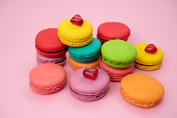 Fototapeta na wymiar Multicolored macaroons on pink background. Sweet and colourful french macaroons