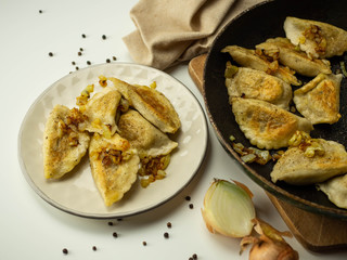 Domowe pierogi z mięsem i smażoną cebulką. Jasne tło. © PhotoHunter