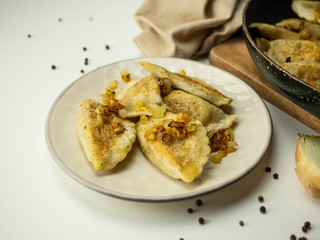 Domowe pierogi z mięsem i smażoną cebulką. Jasne tło. © PhotoHunter