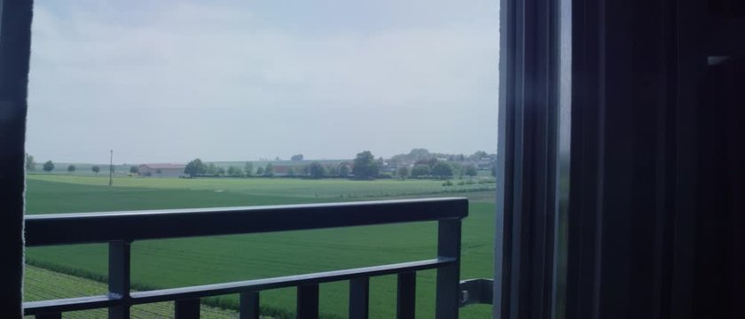 view from a window on a green field from the third floor on an overcast day - Ausblick &uuml;ber ein gr&uuml;nes Feld in l&auml;ndlicher Gegend von einem Zimmer auf der dritten Etage an einem diesigen Tag