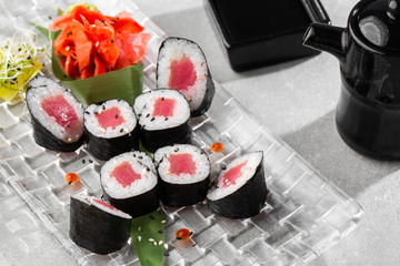 Maki Sushi Rolls with tuna served on transparent plate. Delicious traditional Japanese food, tasty seafood, restaurant concept, food background. horizontal photo