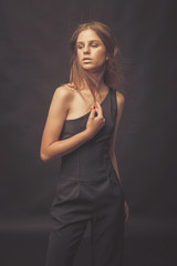 Naklejka premium Fashionable girl in golden gray tones in studio. Woman with unflappable face. Lifestyle concept in fashion world