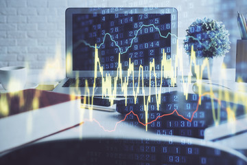 Stock market graph on background with desk and personal computer. Multi exposure. Concept of financial analysis.