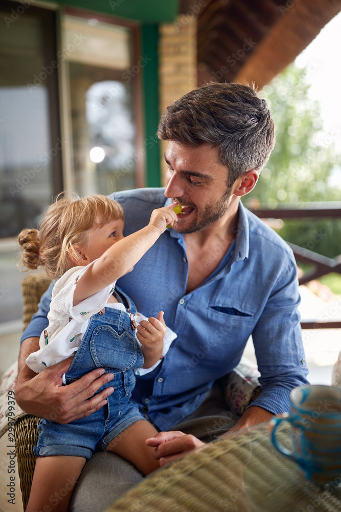 Wall mural child having fun while feeding father