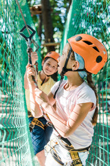selective focus of adorable kids in helmets with height equipment in adventure park