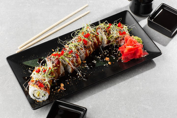 Philadelphia roll sushi with eel, avocado, cream cheese and caviar. Sushi menu. On dark stone plate in white background. Traditional japanese seafood, healthy food concept. Horizontal photo.