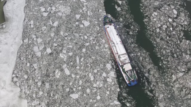 Winter landscape from a height. Barge on the river among the ice floes