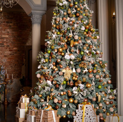  A beautiful Christmas tree stands at home, it is decorated with New Year's toys, snow and an angel, under the tree there are many gifts in a beautiful package that are tied with holiday ribbons. 
