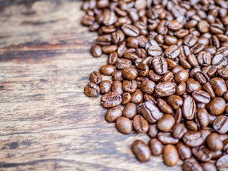 Coffee beans are on the wooden table, ready to give freshness and alongside the businessman