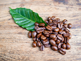 Coffee beans on the wooden table, ready to give freshness and alongside the businessman