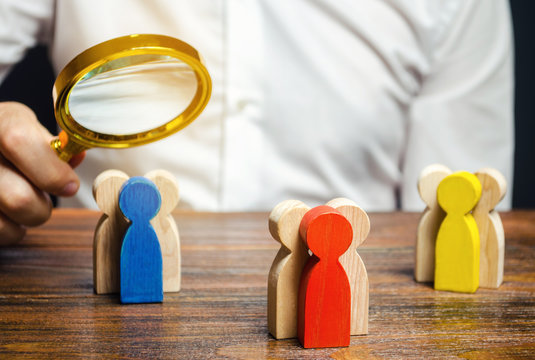 Groups of multicolored wooden people and businessman. The concept of market segmentation. Target audience, customer care. Market group of buyers. Customer relationship management. Selective focus