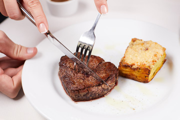 piece of chocolate cake on a plate with fork and knife