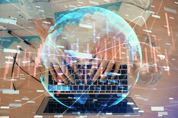 Double exposure of market chart with man working on computer on background. Concept of financial...