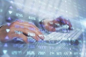 Double exposure of graph with man typing on computer in office on background. Concept of hard work.