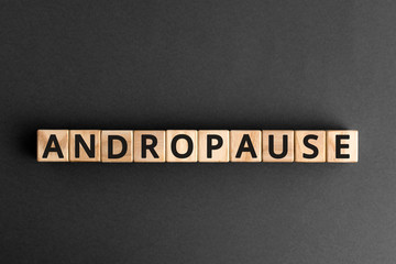 Andropause - word from wooden blocks with letters, symptoms middle-aged men testosterone level...