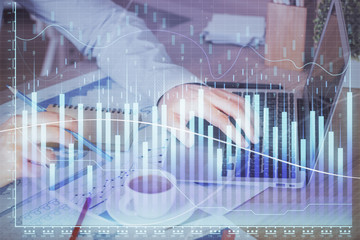 Forex graph with businessman working on computer in office on background. Concept of hardworking....