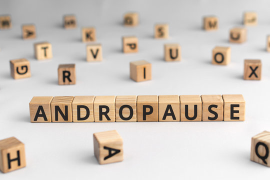 Andropause - word from wooden blocks with letters, symptoms middle-aged men testosterone level andropause concept, random letters around, white  background