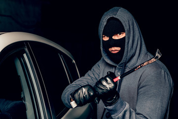 male thief is going to open the car door with a crowbar.