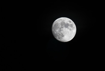 A beautiful telephoto close up view of full moon at night time. Star gazing into space.