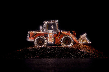 Blurred wheel loader decorated with lights at christmas