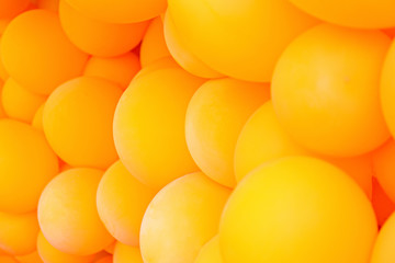 Festive composition with bunch of matte orange balloons. Macro shot, close up, background with a lot of copy space for text.
