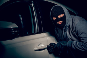 A man with a Balaclava on his head tried to break into the car. He uses a screwdriver. Hijacker,...