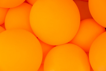 Festive composition with bunch of matte orange balloons. Macro shot, close up, background with a lot of copy space for text.