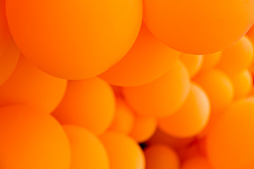 Festive composition with bunch of matte orange balloons. Macro shot, close up, background with a lot of copy space for text.