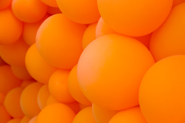 Festive composition with bunch of matte orange balloons. Macro shot, close up, background with a lot of copy space for text.