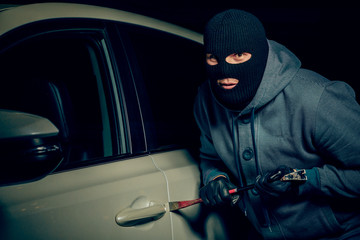 male thief is going to open the car door with a crowbar.