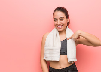 Young fitness woman person pointing by hand to a shirt copy space, proud and confident