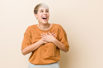 Young plus size woman with short hair laughing keeping hands on heart, concept of happiness.