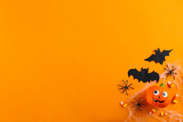 Halloween themed flat lay composition with decorative jack-o-lantern pumpkins, on paper textured background with a lot of space for text. Close up, top view.