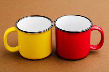 Red and yellow mug, on brown background.