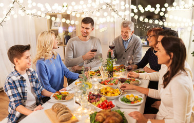 celebration, holidays and people concept - happy family having dinner party, drinking red wine and toasting at home