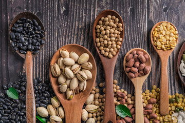 spoons with spices on wooden background